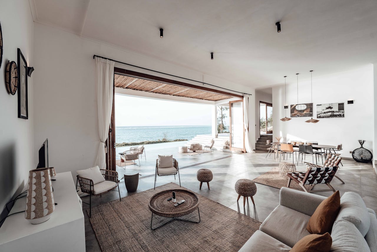 A spacious, minimalistic living room with a stunning ocean view, showcasing modern interior design.